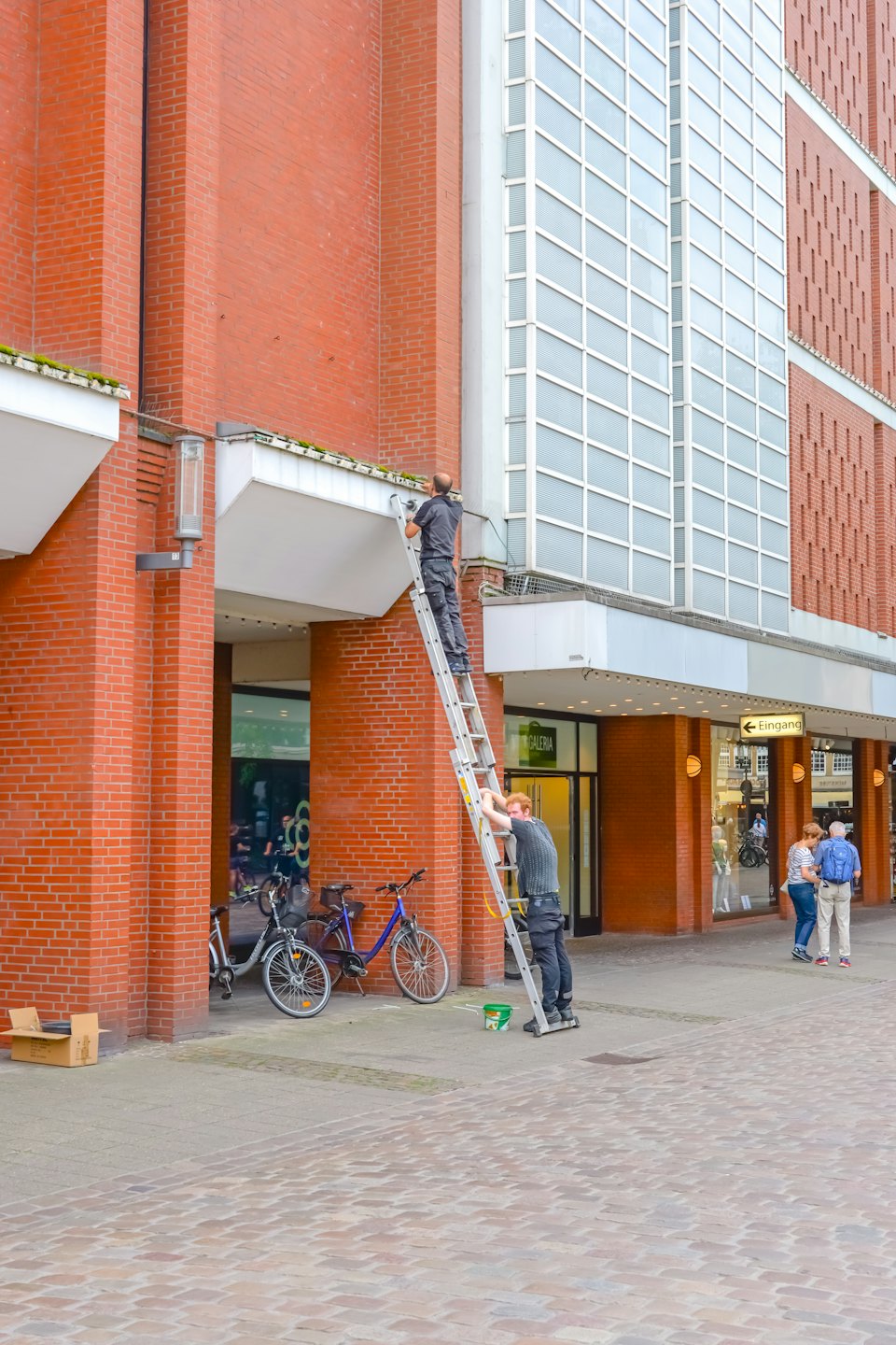 Arbeiter führen Wartungsarbeiten an einer Leiter auf einer Stadtstraße durch.